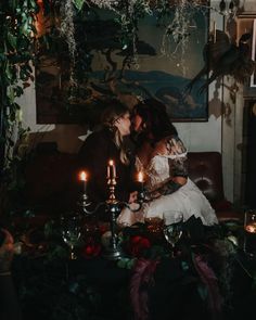 two people sitting on a couch with candles in front of them