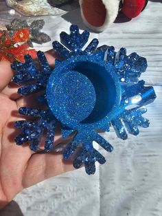 there is a blue ring with snowflakes on it in someone's hand