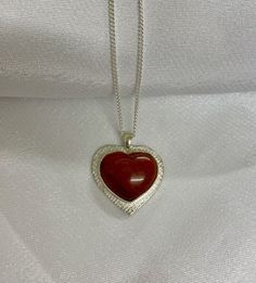 Handmade sterling silver necklace with red jasper semiprecious stone. Can be worn both sides. Texture metal with cut out heart at the back. The stone has beautiful ripples in orange, red and black. Comes in a 16inch sterling silver chain. It will be delivered in a branded pillow box. Can be sent in a gift box on request. Red Sterling Silver Necklace With Heart Pendant, Red Heart-shaped Sterling Silver Necklace, Red Gemstone Heart Pendant Necklace, Red Sterling Silver Heart Charm Necklace, Red Sterling Silver Heart Pendant Jewelry, Red Sterling Silver Heart Pendant Necklace, Red Heart-shaped Engraved Jewelry, Red Heart Pendant Necklace In Sterling Silver, Red Gemstone Sterling Silver Necklace