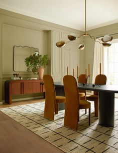 a dining room table and chairs with an area rug on the floor in front of it