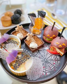 an assortment of desserts are arranged on a plate with purple umbrellas and sprinkles