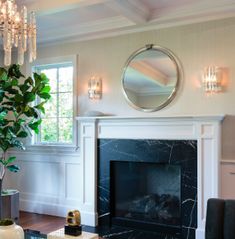 a living room filled with furniture and a fire place in front of a mirror on the wall