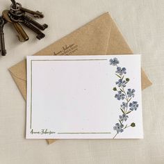 a card with blue flowers on it next to keys