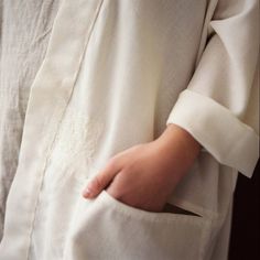 a close up of a person's hand holding something in their left arm and wearing a white shirt