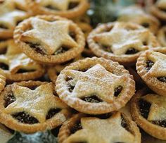 many small pies are stacked on top of each other with powdered sugar on them