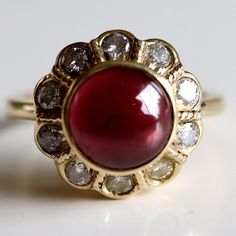 This dramatic ring demand an evening on the town. 0.67 carats of hand faceted diamonds are paired with an oversized cabochon garnet and set in 14k gold. Ring size ranges from 5-8. Garnet And Diamond Ring, Replica Jewelry, Winter Jewelry, Jane Seymour, Citrine Earrings, Medieval Jewelry, Red Jewelry, Garnet Jewelry, White Jewelry