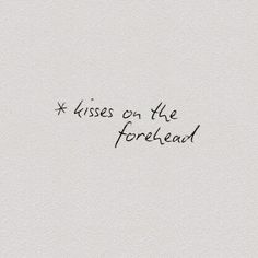 the words are written in black ink on a white paper background, which reads kisses on the forehead