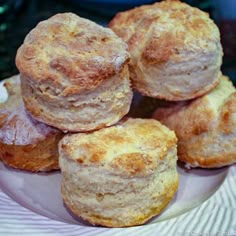 some biscuits are stacked on top of each other in a white plate with a striped napkin