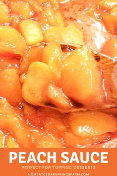 peach sauce is being stirred with a wooden spoon