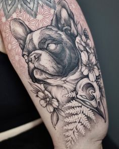 a black and white tattoo of a dog with flowers