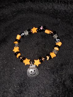 Halloween bracelet handmade with pumpkin charm and various black and orange beads. Bracelet is supported by a colored cord. Handmade with love and care in North Carolina, United States!! Handmade Casual Halloween Jewelry, Casual Black Bracelets For Halloween, Casual Handmade Halloween Jewelry, Casual Handmade Jewelry For Halloween, Halloween Black Charm Bracelet, Orange Beaded Bracelets For Halloween Gift, Orange Beaded Bracelets For Halloween, Handmade Orange Bracelets For Halloween, Gothic Bracelet