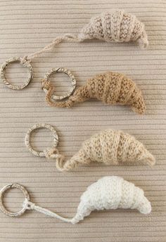 four knitted objects are arranged on a table top, including rings and yarns