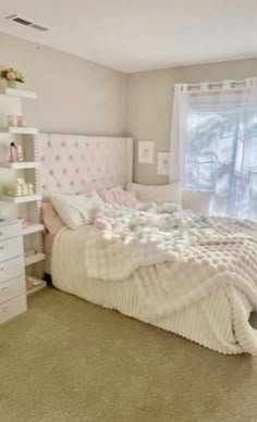 a bedroom with a bed, dressers and window in it's center area