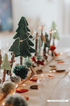 the table is decorated with small trees and lights