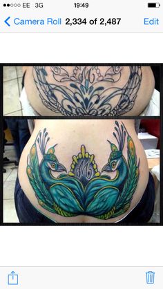 the back of a woman's stomach with tattoos on it and an image of two peacock