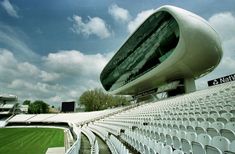 an empty stadium filled with white chairs under a cloudy sky