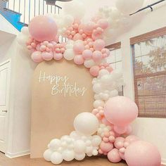 an arch made out of balloons with the words happy birthday written in white on it