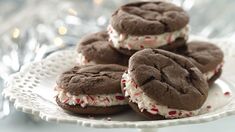 chocolate cookies with white frosting and sprinkles on a plate