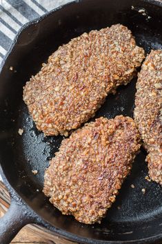 three meat patties cooking in a skillet