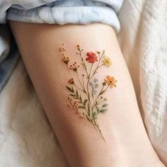 a small flower tattoo on the right side of the leg, with tiny flowers all over it