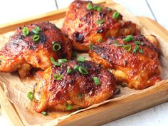 chicken wings with green onions on a wooden tray