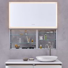 a white sink sitting under a bathroom mirror next to a shelf filled with other items