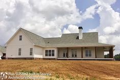 a large white house sitting on top of a dry grass field