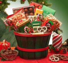 a basket filled with lots of holiday treats on top of a red cloth covered table