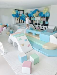 a child's play area with blue, pink and white furniture in the background