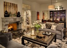 a living room filled with furniture and a fire place in the middle of a room