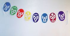 the colorful nail art is hanging on the wall in front of the white wall, and there are five pairs of masks