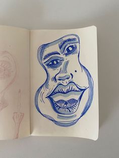 an open book with a drawing of a man's face on the cover and another drawing of a woman's head