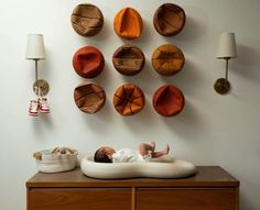 a baby laying on top of a bed in front of a wall mounted basketballs