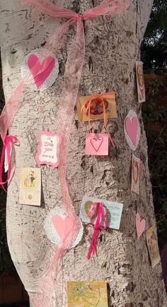 a tree has been decorated with pink hearts and cards for valentine's day on it