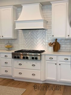 a kitchen with white cabinets and an oven