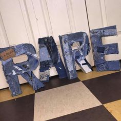 letters made out of jeans sitting on the floor next to each other in front of a door