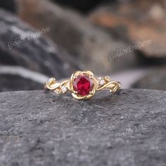 a red stone ring sitting on top of a rock