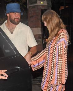 a man and woman shaking hands in front of a car