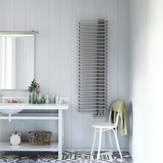 a bathroom with a sink, mirror and radiator in the wall next to it