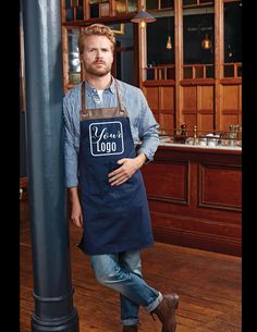 a man wearing an apron standing next to a pole