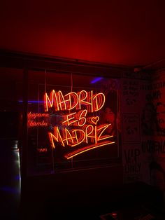 a neon sign that says madrid e & ampre in red and blue lights on the wall