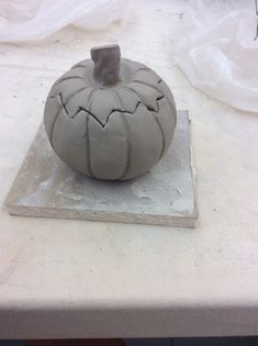 a clay pumpkin sitting on top of a table