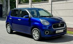 a blue car parked in front of a building