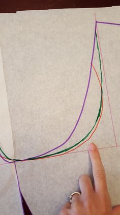 someone is drawing a curve on paper with colored crayons