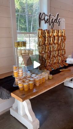 a wooden table topped with lots of donuts next to a sign that says petale's