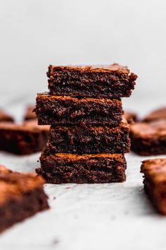 a stack of brownies sitting on top of a white table next to each other