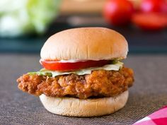 a chicken sandwich with lettuce, tomato and mayonnaise