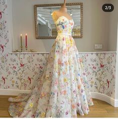 a dress on display in front of a wallpapered room with flowers and butterflies