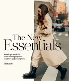 a woman walking across a cross walk in front of a white sign that says the new essentials