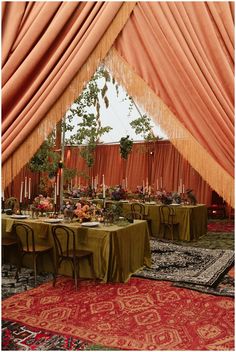 a tent with tables and chairs set up for a formal dinner in the middle of it